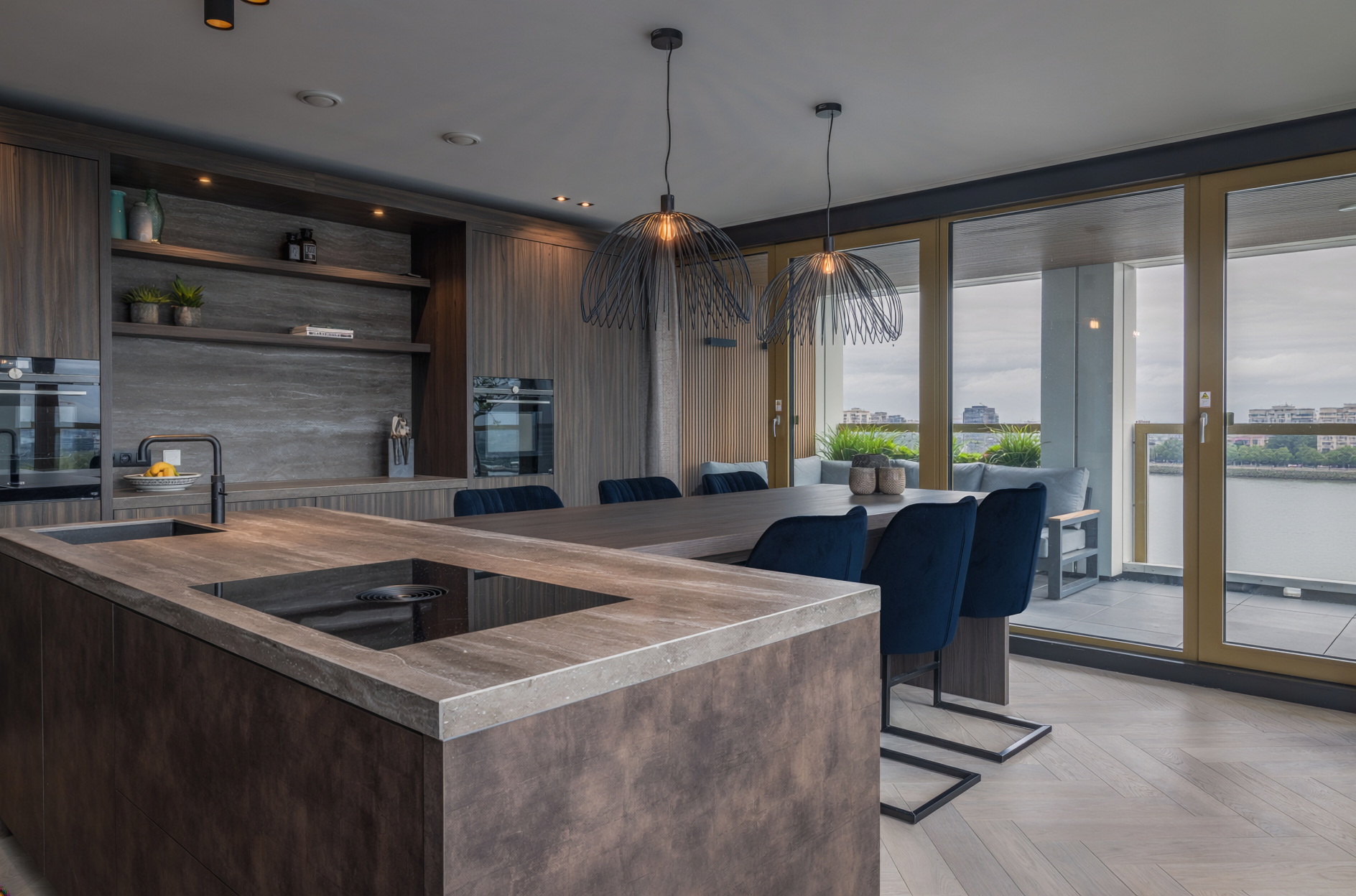 Penthouse - Keukeneiland met eettafel en draadlampen met uitzicht op balkon