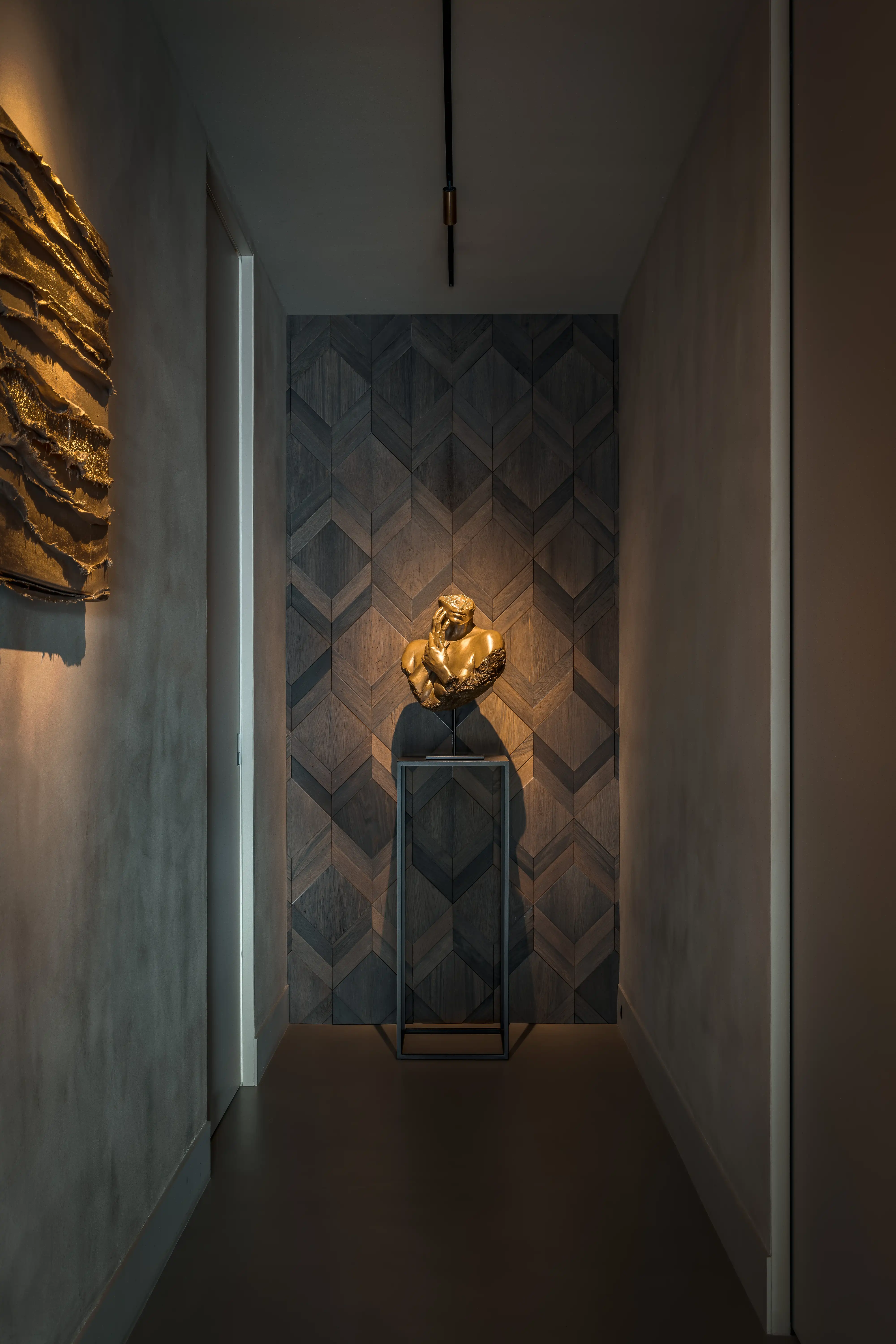 Villa aan het Water - Gang met visgraat houtpanelen en gouden sculptuur