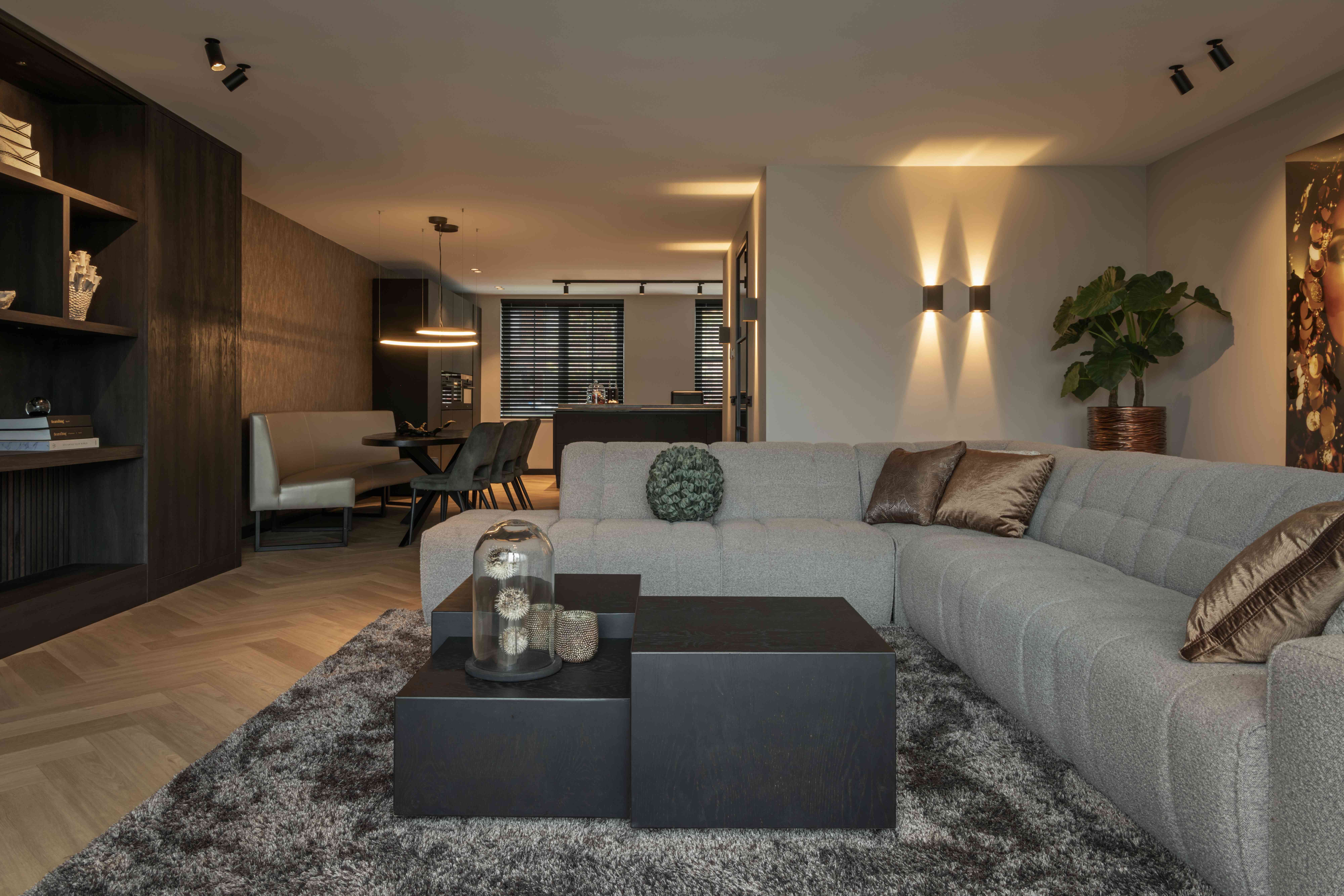 Wonen aan het water Waddinxveen - Grijze loungebank met sfeervolle wandlampen