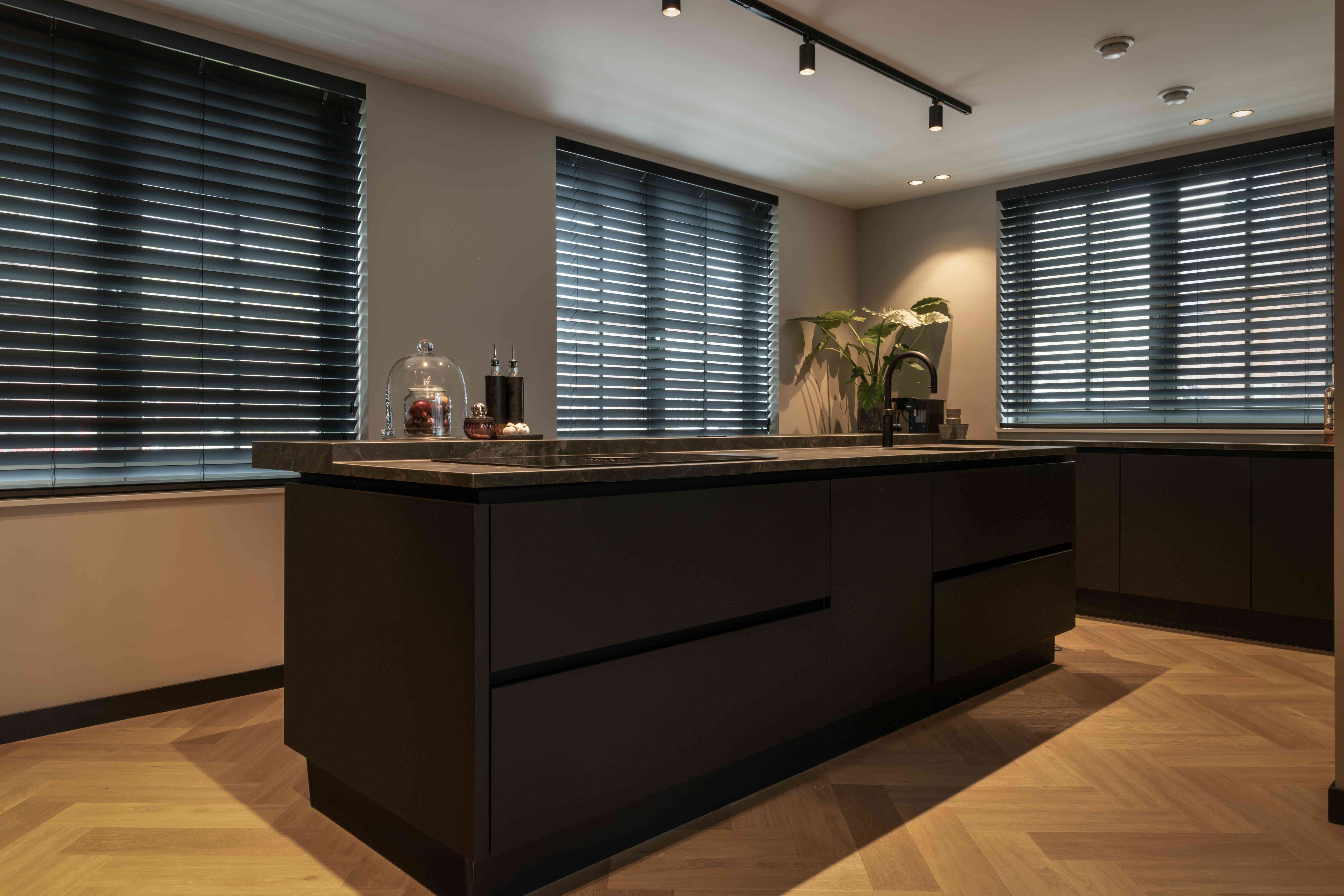 Wonen aan het water Waddinxveen - Moderne zwarte keuken met stenen blad